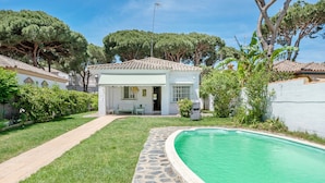 Une maison avec une piscine, un chemin de pierre et un jardin.