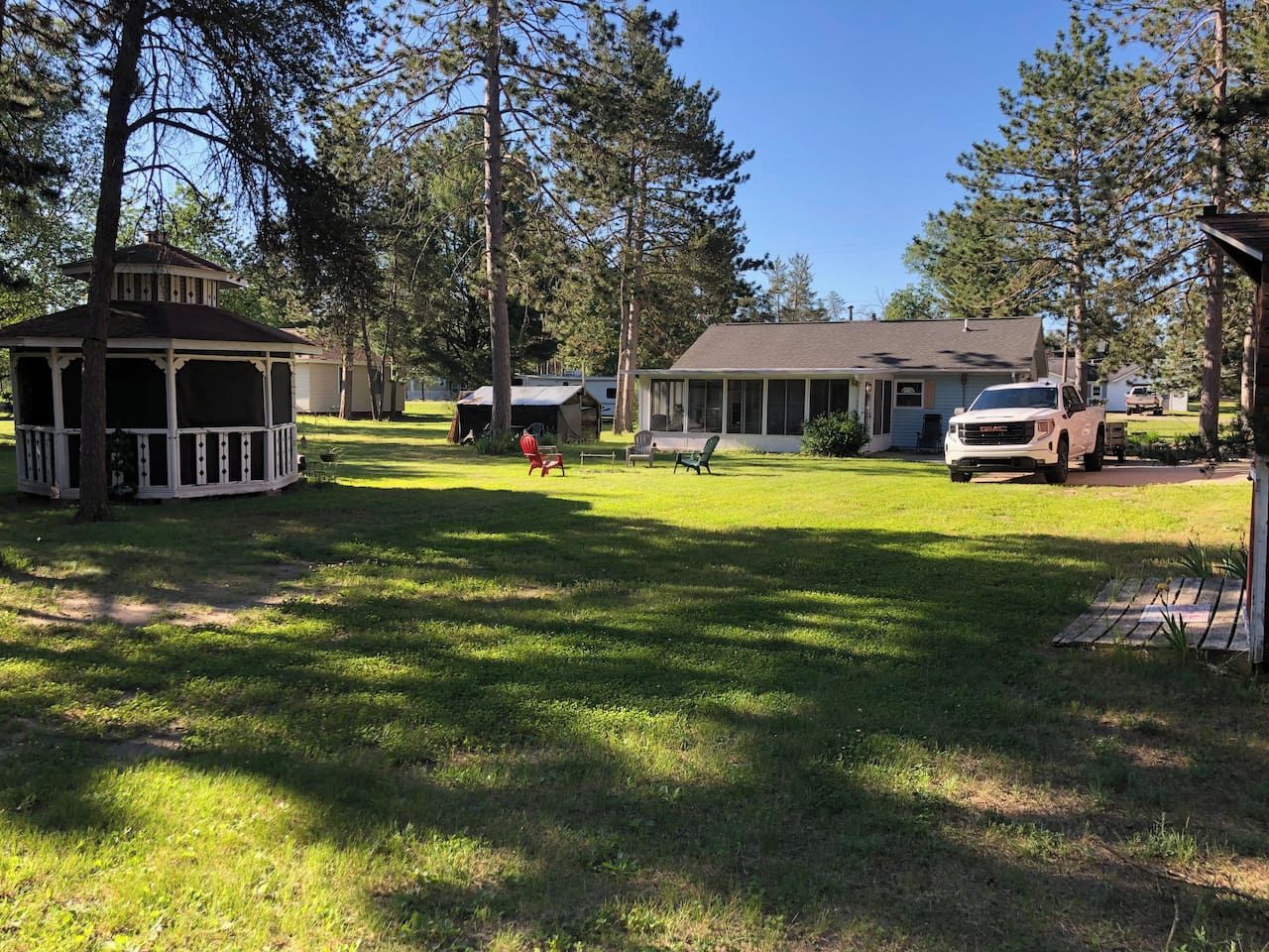 A residential area with a gazebo, a house, and a truck parked in the driveway.
