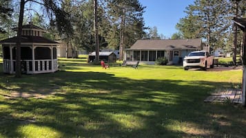 A residential area with a gazebo, a house, and a truck parked in the driveway.