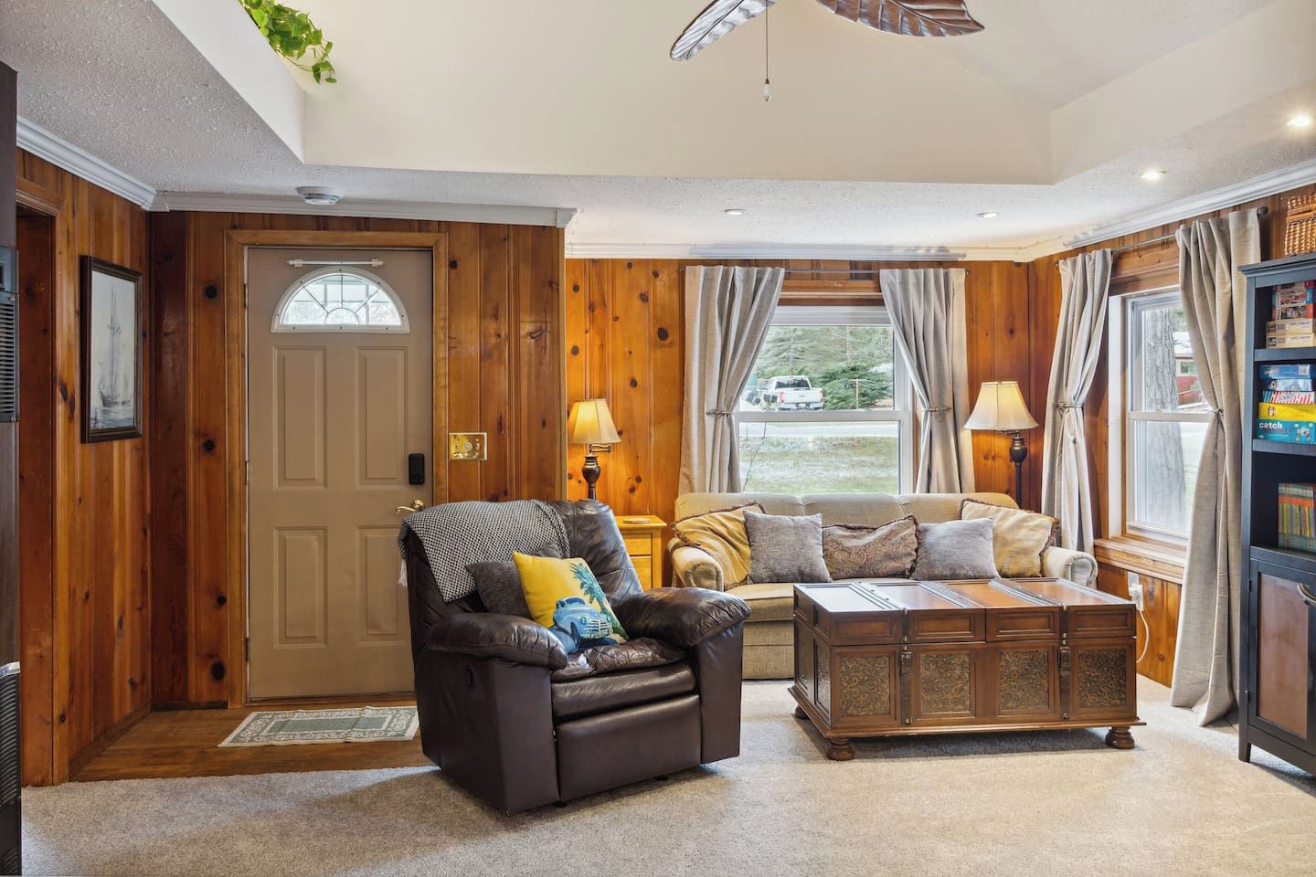 A cozy living room with a leather sofa, a wooden coffee table, and a fireplace.