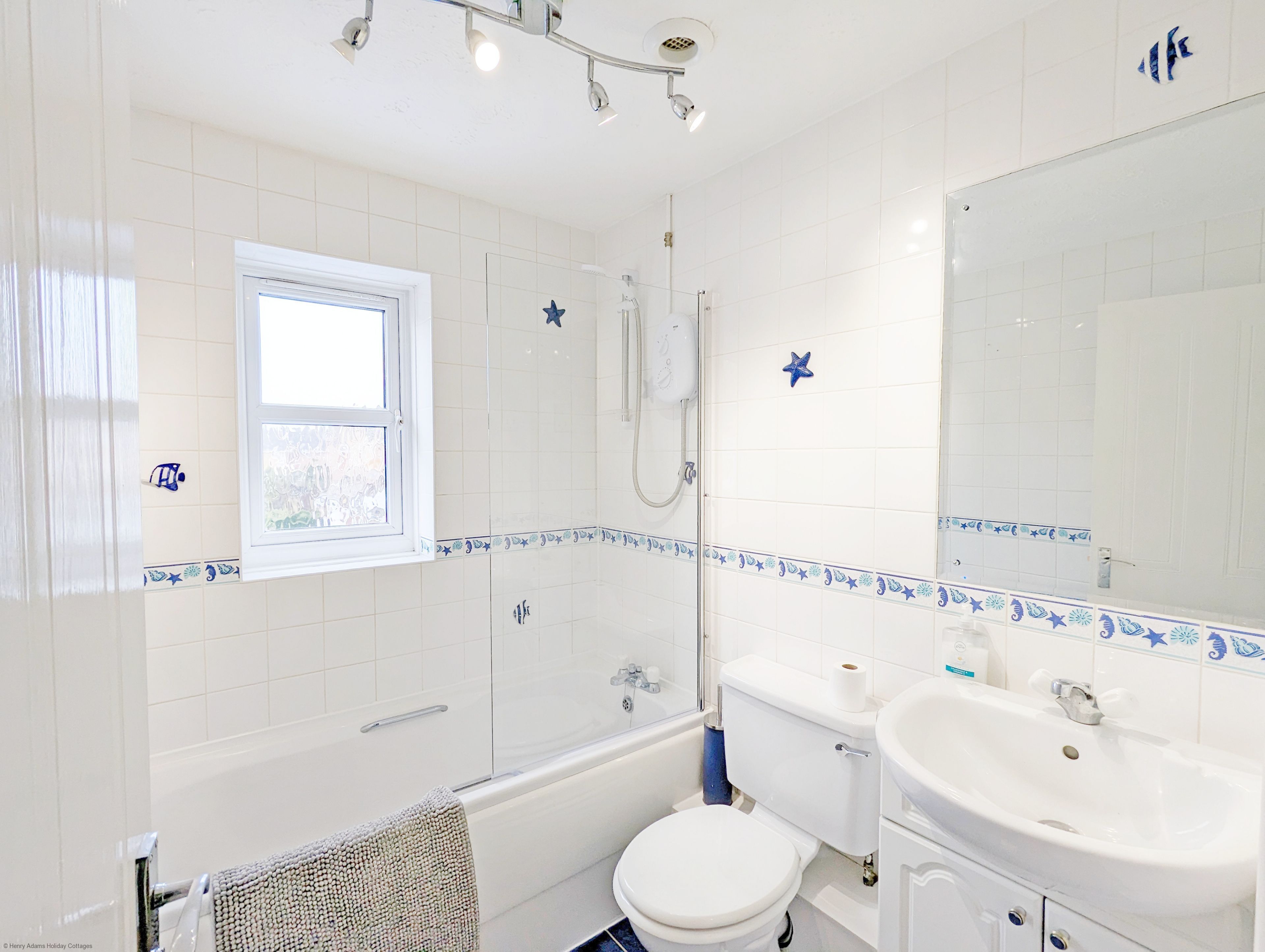 Ein Badezimmer mit Badewanne, Toilette, Waschbecken und einem Fenster.