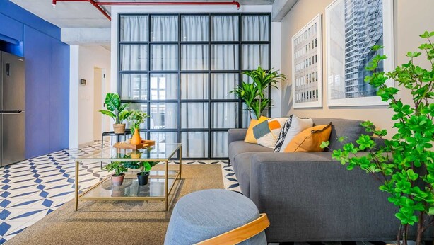 Una sala de estar moderna con un sofá, una mesa de centro y plantas en macetas.