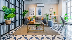 Una sala de estar moderna con un sofá, una mesa de centro y plantas en macetas.