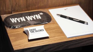 A wooden table with a black bag labeled "WYN WYN," a pen, and a note saying "ENJOY THE SILENCE." - w* | Luminous 1BR with Amazing Deco in Polanco (Ciudad de México)