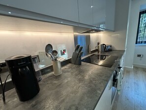 A modern kitchen with a built-in espresso machine, a kettle, and a toaster. - Solihull Studio • WiFi • NEC • BHX (Solihull)