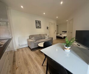 Un salon moderne avec un canapé, une table à manger et un téléviseur.