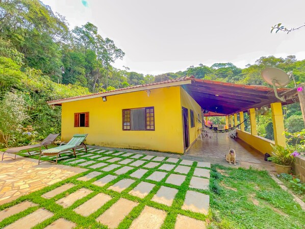 A yellow house with a tiled patio and a covered porch.