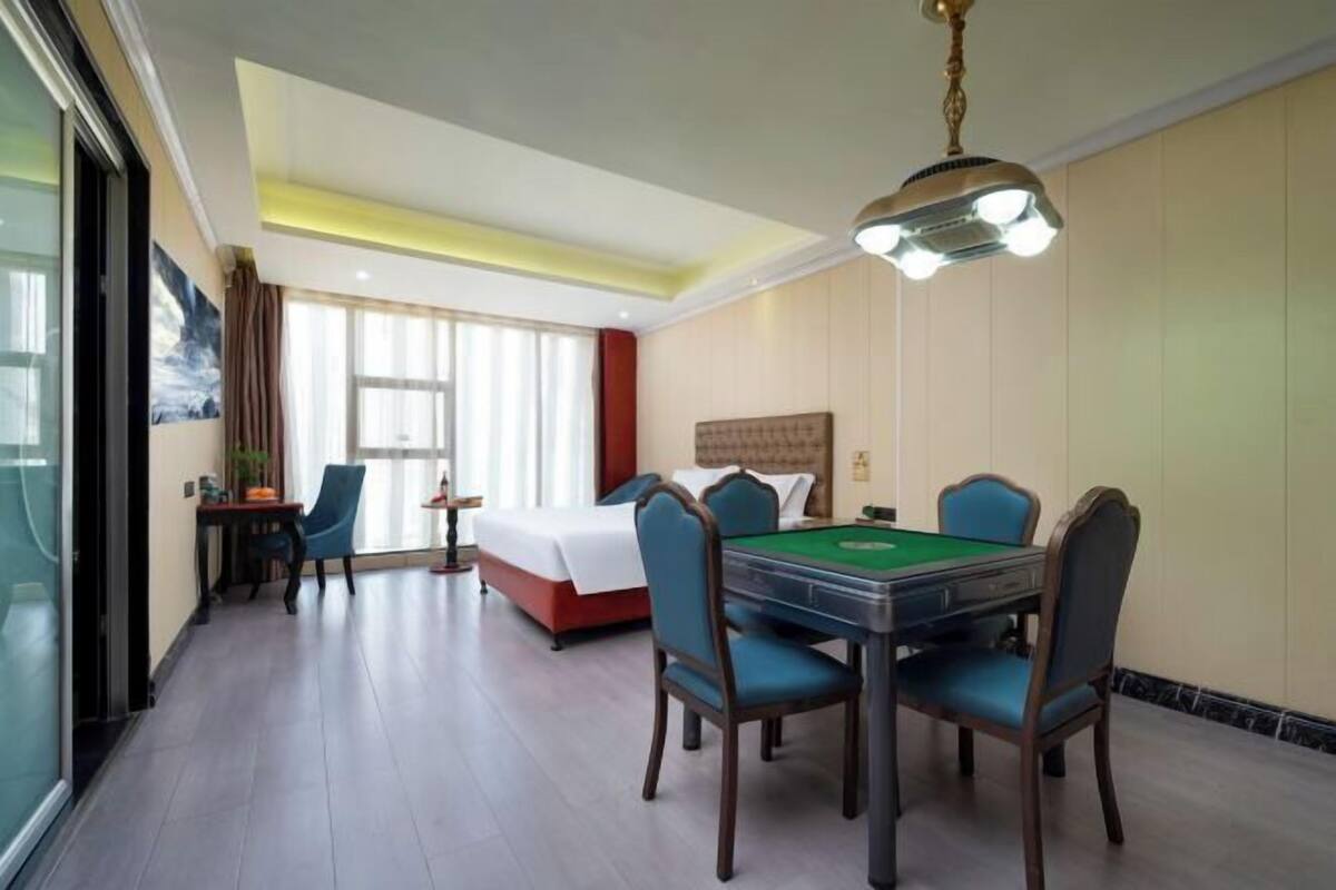 Una habitación de hotel con mesa de billar, una cama y un comedor.