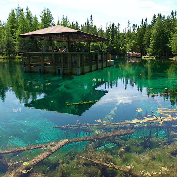 A clear lake with a wooden dock and a covered seating area. - Hot Tub House Kipling Cottages Deck Fire Pit 2 bed 1 bath Smart TVs WiFi Sleep 6 (Gladstone)