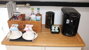 A kitchen counter with a coffee maker, a box of champagne, and a container of cookies. - The White Lion (Ventnor)