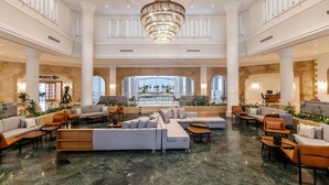 A spacious lobby with a large seating area, a bar, and a view of a pool. - Casa Blue Resort (Marsa Alam)
