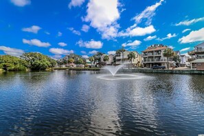Surrounded by lush greenery and a central fountain, this waterfront setting offers a peaceful living environment.