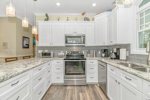 Enjoy cooking in this well-lit kitchen with oven, microwave, and granite countertop.