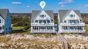Ein strandnahes Anwesen mit einem zentralen Haus, das einen Balkon und eine Terrasse besitzt.