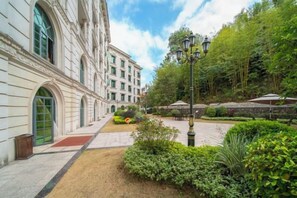A courtyard with a building, a lamp post, and greenery. - Guangning Overseas Chinese Hotel (Guangning)