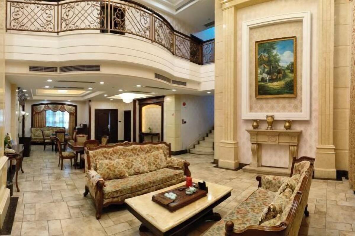 Un hall d’entrée spacieux, doté d’un plafond haut, de balustrades décoratives et d’un grand tableau mural.