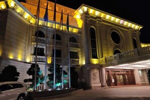 A large building with multiple columns and a grand entrance, illuminated at night. - Guangning Overseas Chinese Hotel (Guangning)