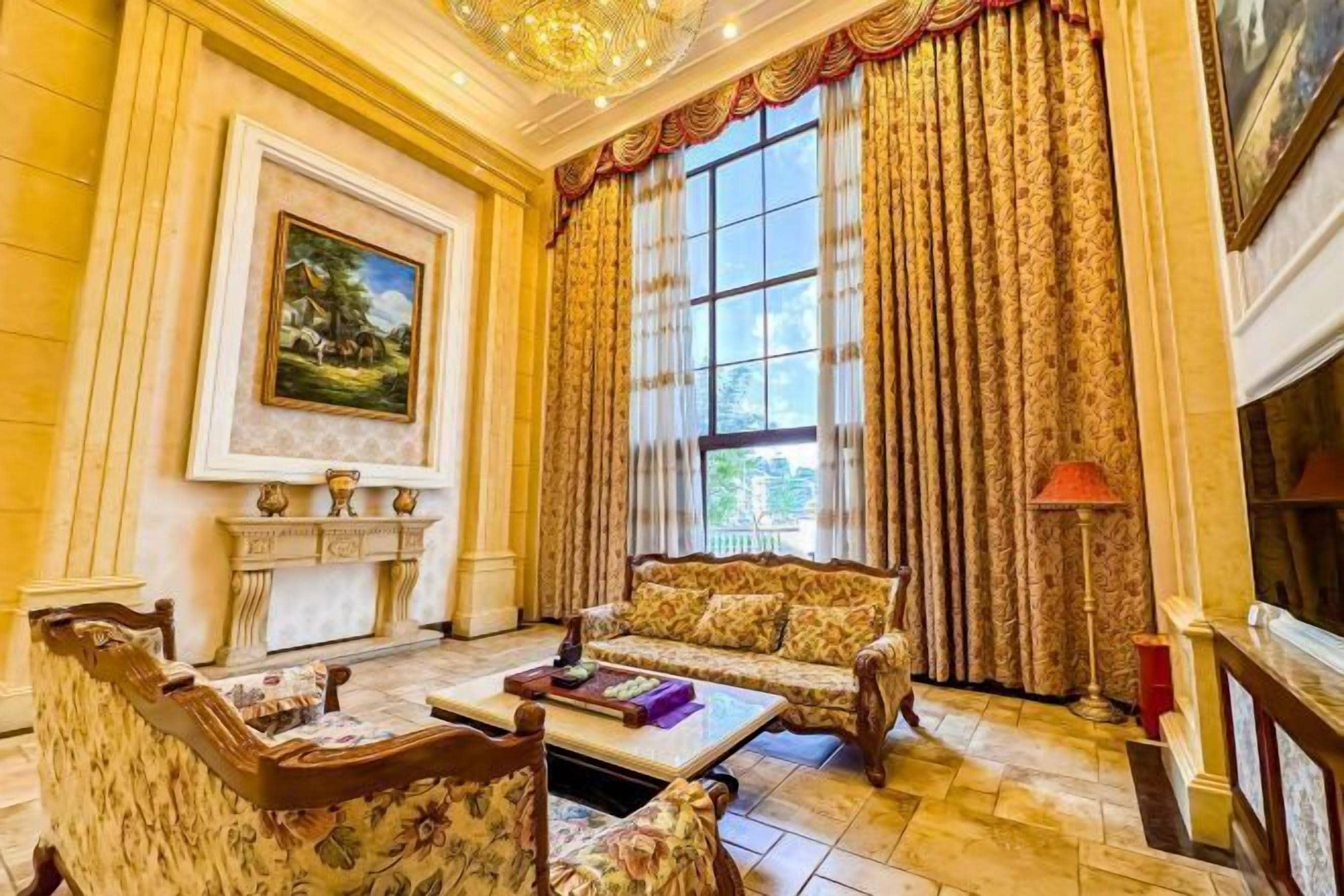 Une pièce avec une cheminée, un canapé, une table basse et un tableau au mur.