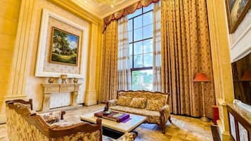 Une pièce avec une cheminée, un canapé, une table basse et un tableau au mur.
