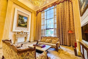A room with a fireplace, a sofa, a coffee table, and a painting on the wall.