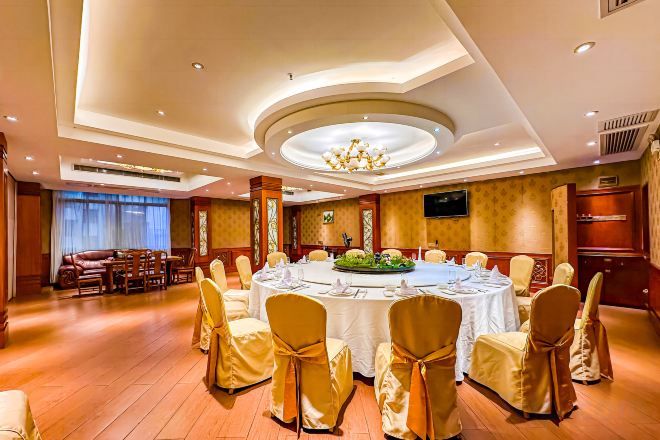 Un salón de conferencias con una mesa redonda, sillas y un candelabro.