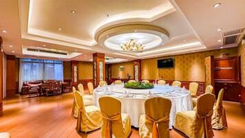 Un salón de conferencias con una mesa redonda, sillas y un candelabro.