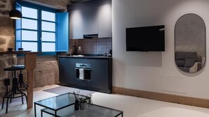 A modern kitchen with a built-in oven, a bar area, and a large window. - Houmi Orzán - Apt. Rosalia de Castro (A Coruña)