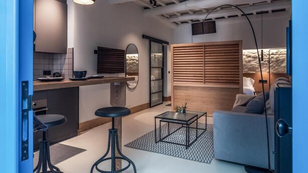A modern interior with a kitchen, dining area, and seating space. - Houmi Orzán - Apt. Rosalia de Castro (A Coruña)