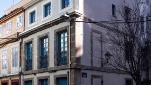 A multi-story building with a red roof, blue doors, and a sign indicating 'Vista'. - Houmi Orzán - Apt. Rosalia de Castro (A Coruña)
