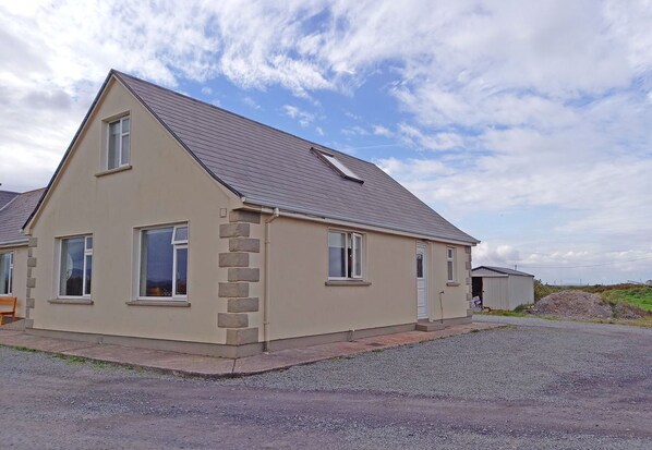 Situated on a driveway, this charming house features a gabled roof and attached garage.