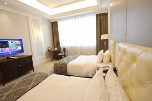 A hotel room with two beds, a TV, a desk, and a lamp. - Ruipu Hotel (Daozhen)