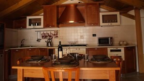 Une cuisine avec des meubles de rangement en bois, un îlot central, un four à micro-ondes et un évier.