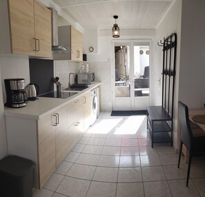 Una cocina moderna con una isla central, un lavamanos y una zona de comedor con banco.