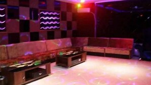 A room with a checkered wall pattern, a sofa, and a small table.