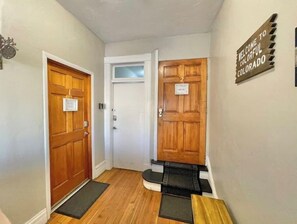 Welcome to a cozy waiting area with a bench and table, featuring a door with a sign reading '2'.