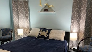 Una camera d'albergo con un letto, due poltrone, una lampada e un elemento decorativo a parete.