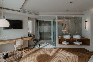 Une salle de bain moderne avec un grand miroir, deux lavabos et une douche.