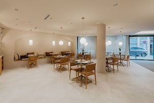 Un comedor moderno con mobiliario de madera e iluminación colgante.