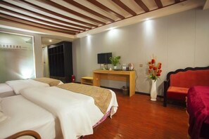 A hotel room with two beds, a wooden desk, a television, and a red sofa. - Huaqiao Holiday Hotel (Guiyang Huaguoyuan) (Guiyang)
