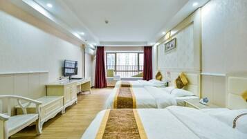 A hotel room with two beds, a TV, a desk, and a window with curtains.