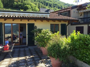 Una casa con patio, plantas en macetas y vistas a las montañas.