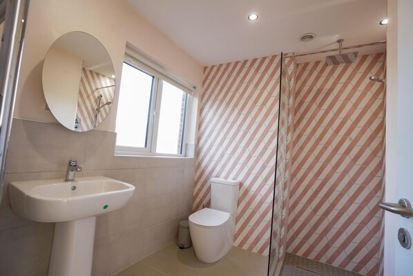 A bathroom with a sink, toilet, and shower.