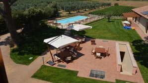 Eine Terrassenanlage mit Pool, Gartenmöbeln und Blick auf die umliegende Landschaft.