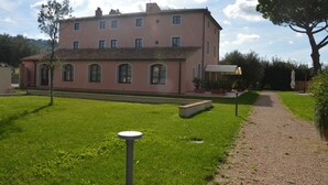 Ein pinkfarbenes Gebäude mit einem Garten davor.