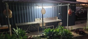 A bathroom with a large sink, a mirror, and a shower area. There are plants in the foreground. - Roo Or 2 on Streeter (Agnes Water)
