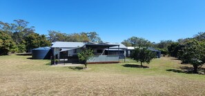 A residential property with a large house, a covered outdoor area, and a fenced yard. - Roo Or 2 on Streeter (Agnes Water)