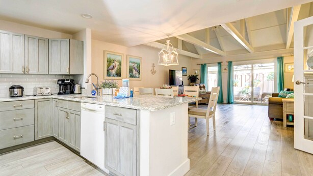 A spacious kitchen with a central island, a dining area with a view, and a living space with a large window. - Community Perks! Sunny Hilton Head Island Retreat (Hilton Head Island)