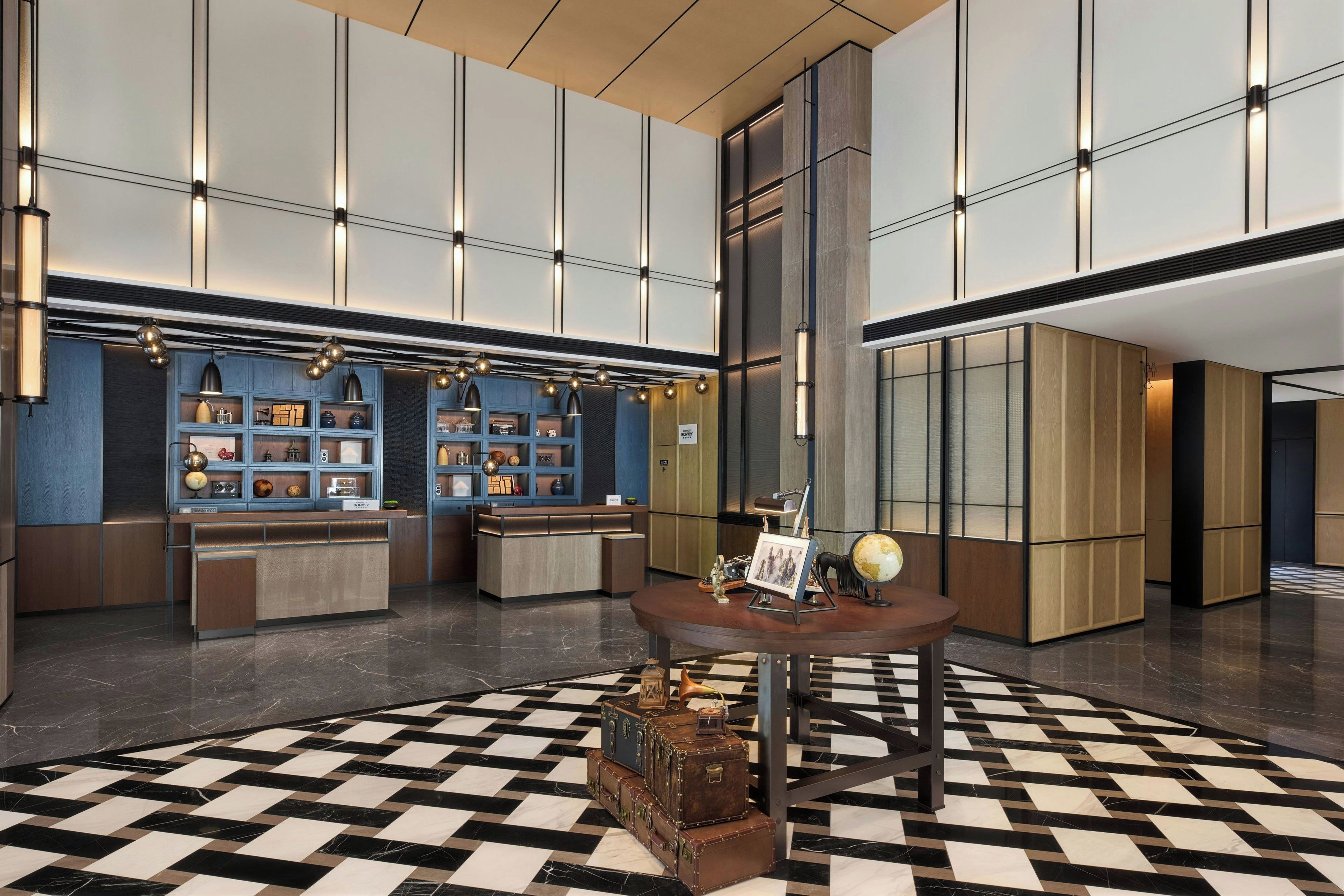 A hotel lobby with a check-in desk, a reception area, and a large checkered floor pattern.