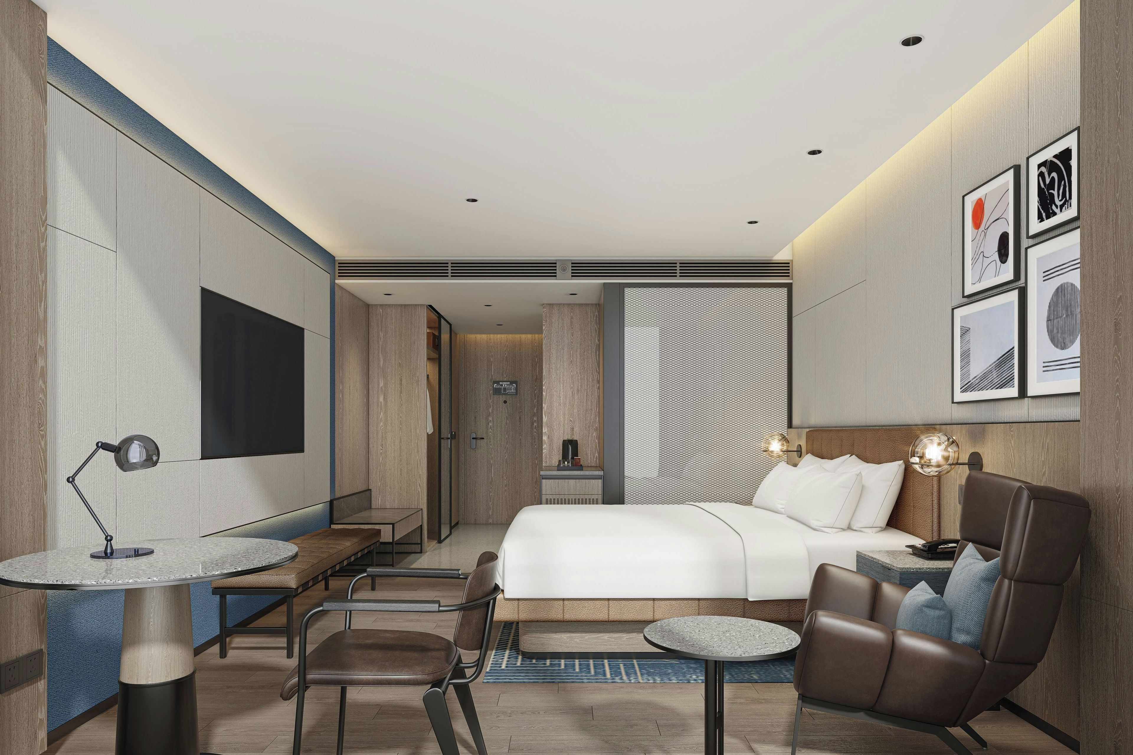 Una habitación de hotel moderna con cama, escritorio, silla y obras de arte en las paredes.