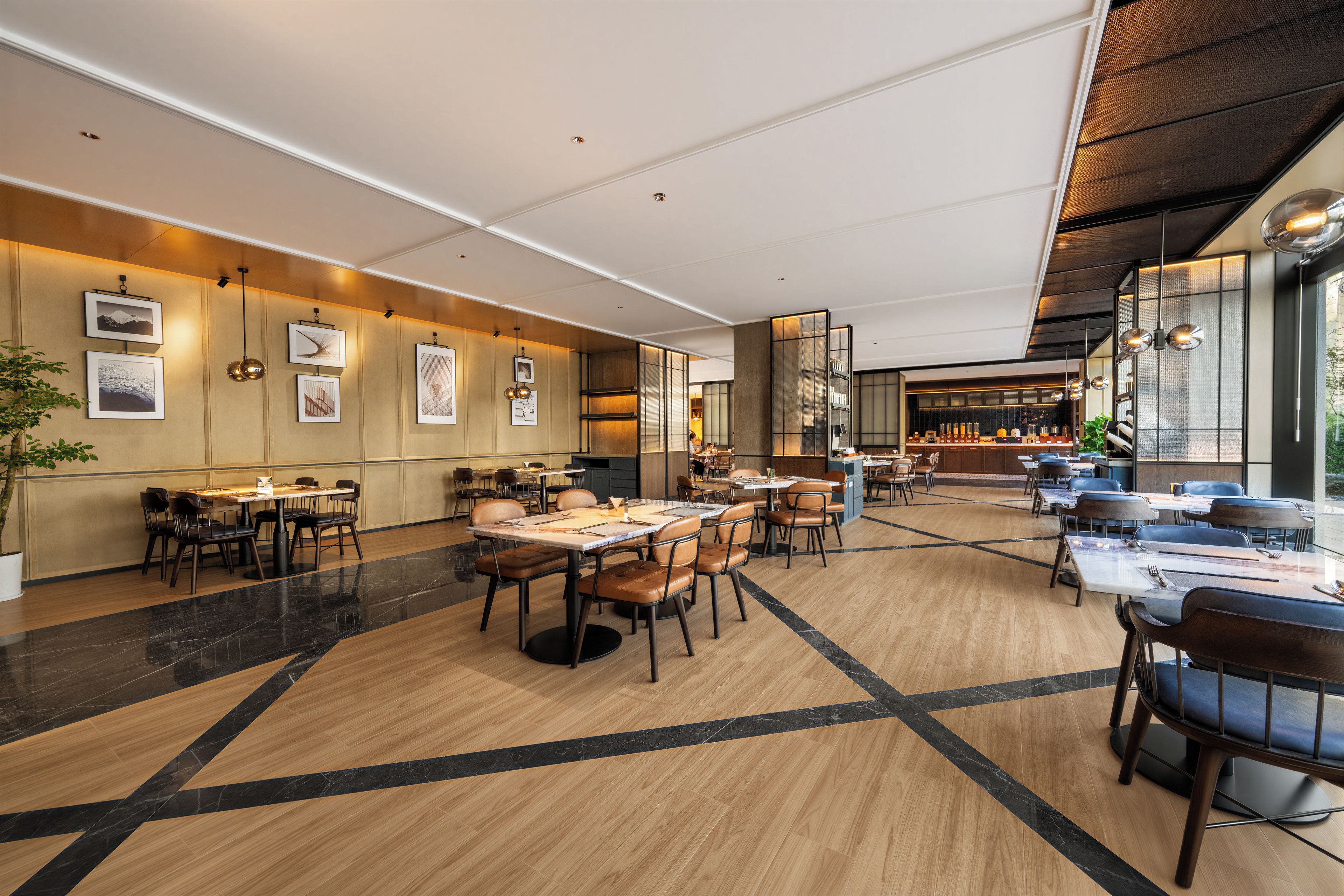 Un restaurante espacioso con techos altos, iluminación moderna y una variedad de disposiciones de asientos.